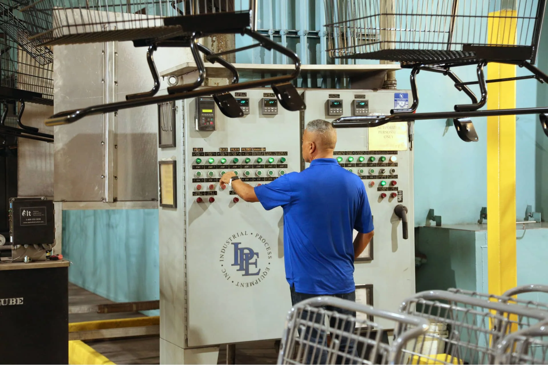 Peggs employee controlling a powder coat machine